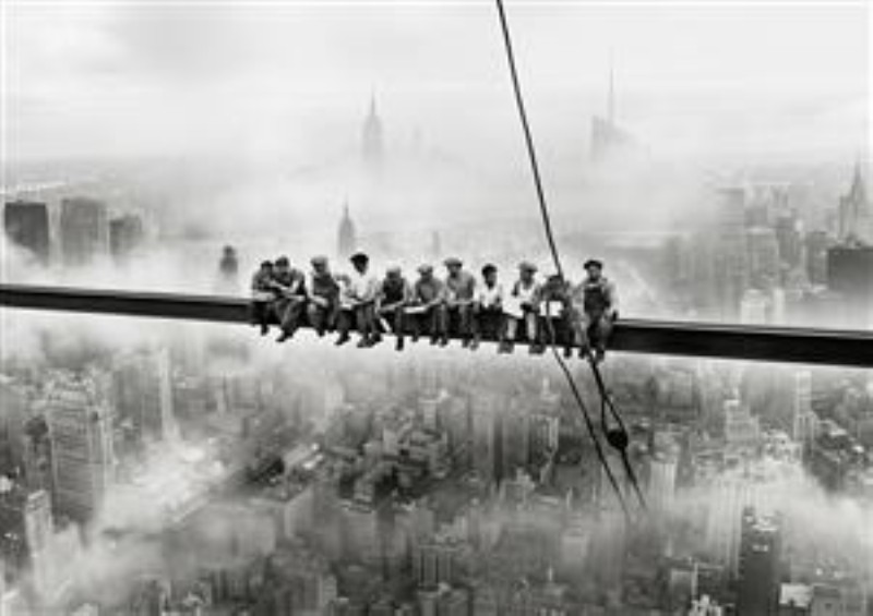 Arbejdere på bjælke over New York - Sort-hvid fotografisk plakat med arbejdere siddende på en stålbjælke højt over New Yorks tågede skyline. Et ikonisk historisk motiv med urban stemning, arkitektur og dramatisk perspektiv, velegnet til kontor, stue eller industrielt inspireret indretning.